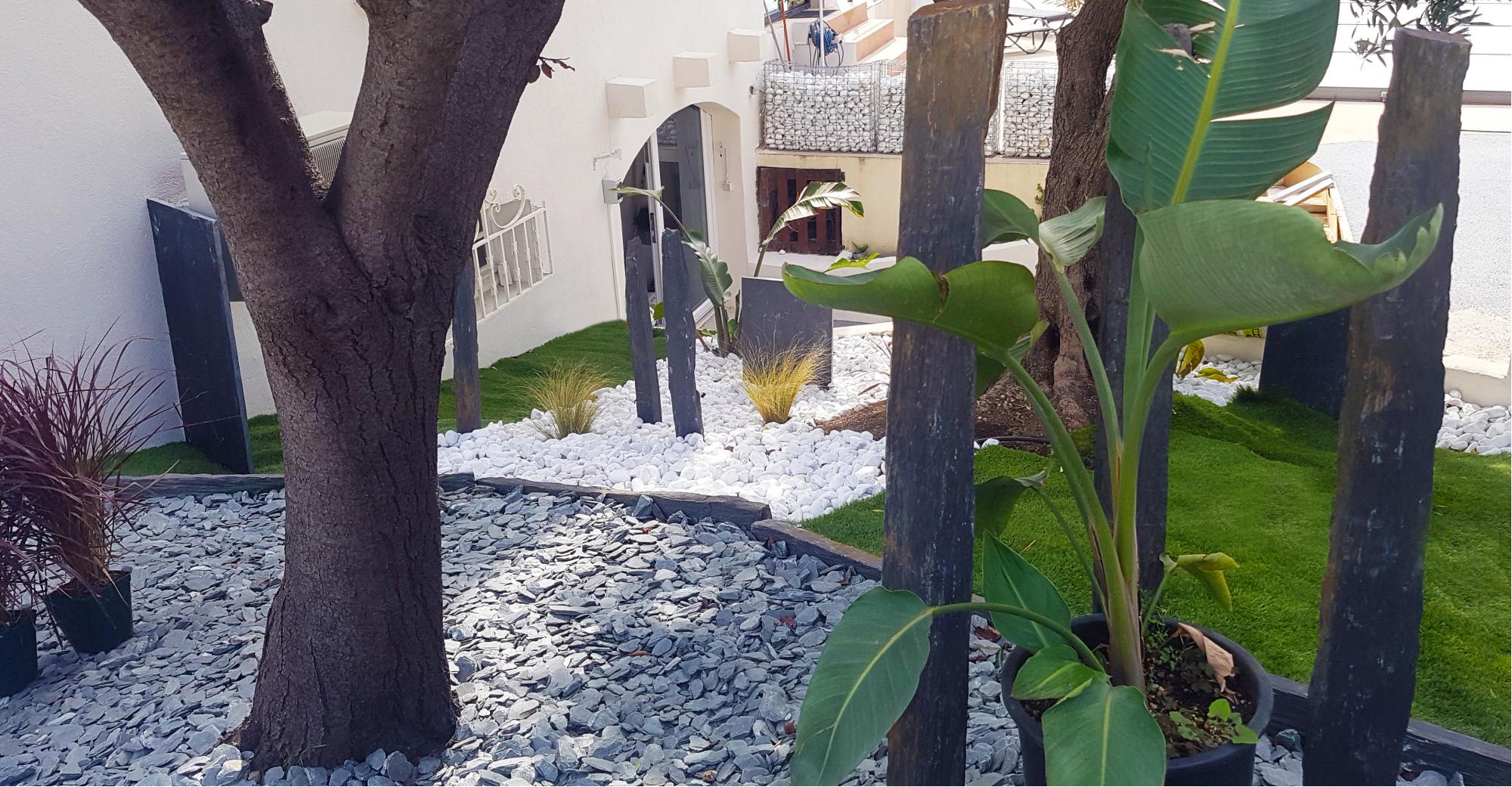 Jardin en paillettes de schiste ardoisier, galets blancs de carrare et piquets de schiste