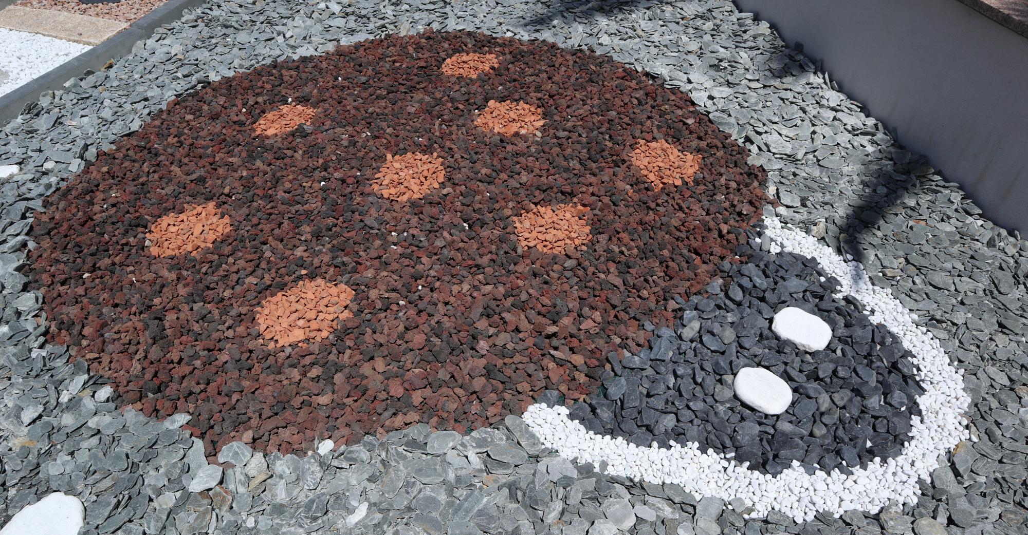 Corps coccinelle : Pouzzolane et brique pilée
Tête coccinelle : Noir Igea, blanc de Carrare et Discus
Fond en copeaux de schiste ardoisier