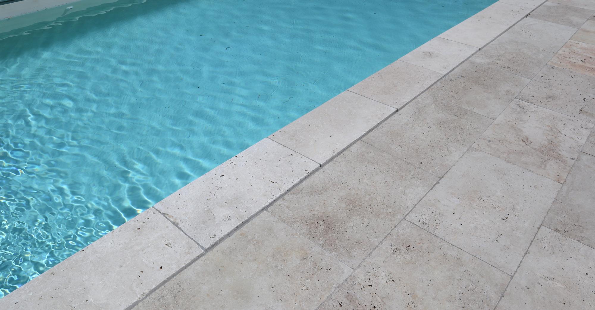 Plage et contour piscine en travertin
