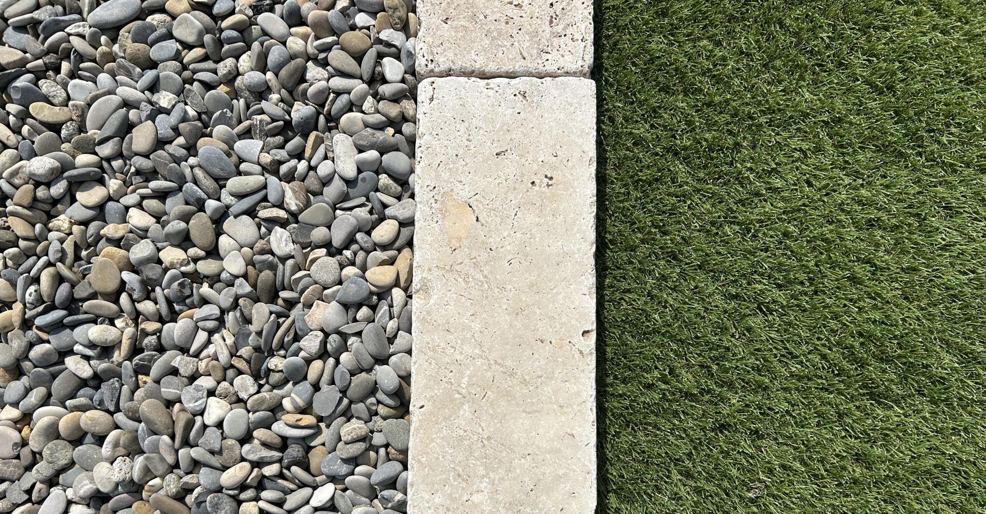 Galets gris de Durance, bordure en travertin, gazon synthétique